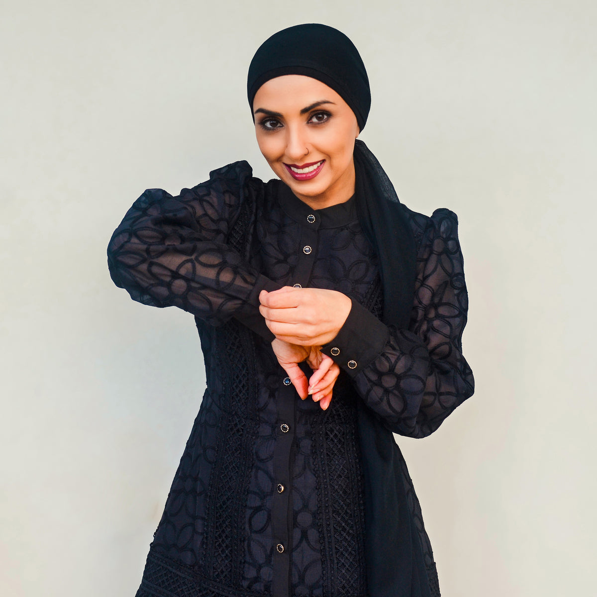 Woman wearing the Celeste Bloom Lace Midi Dress in black, featuring delicate lace, embroidered details and a modest feminine silhouette.